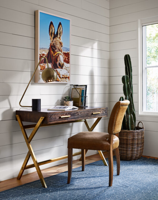 Wood study table, chair, painting, and a plant in a room